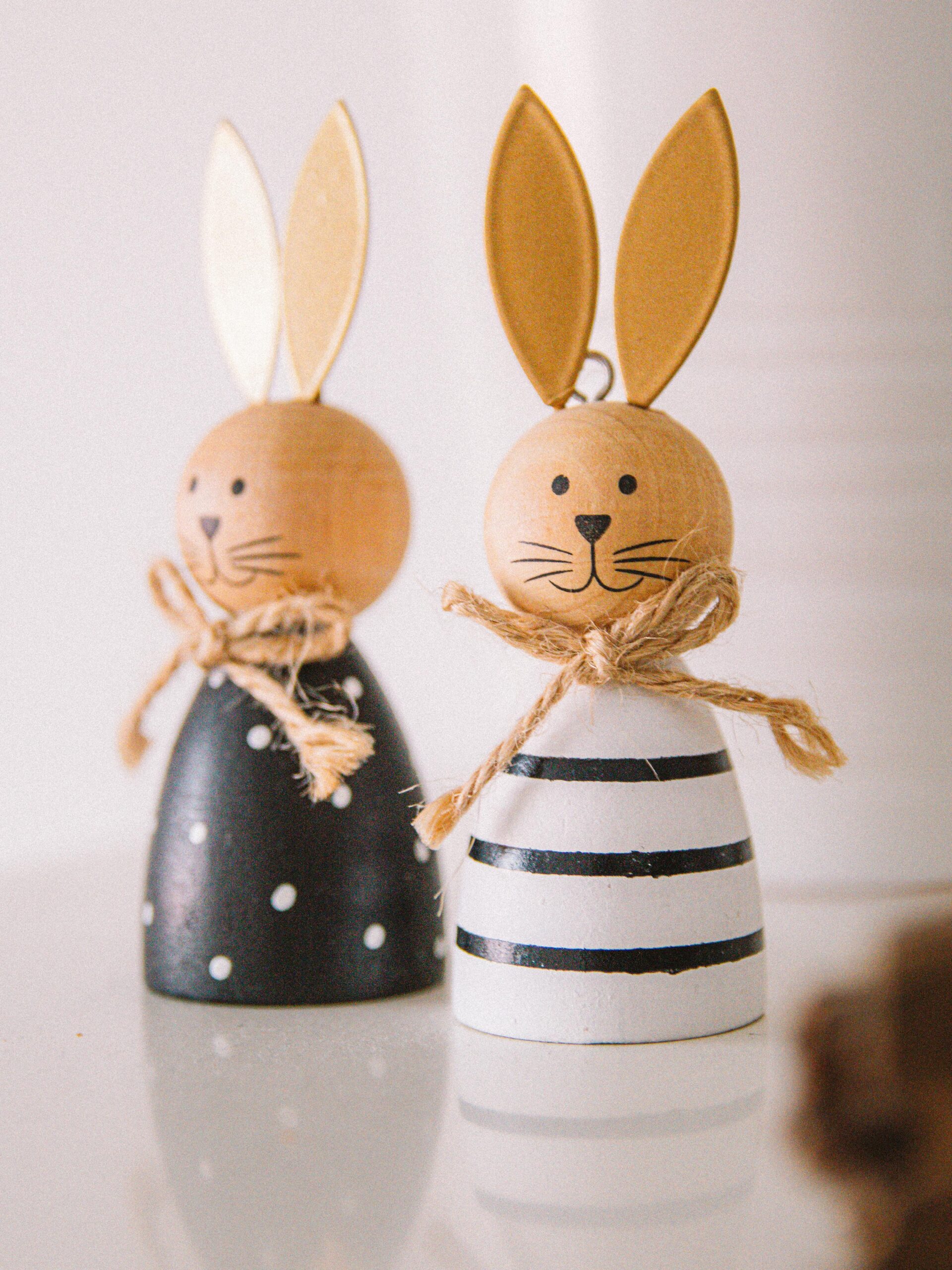 Charming decorative wooden rabbits with golden ears and twine bows, perfect for festive decor.
