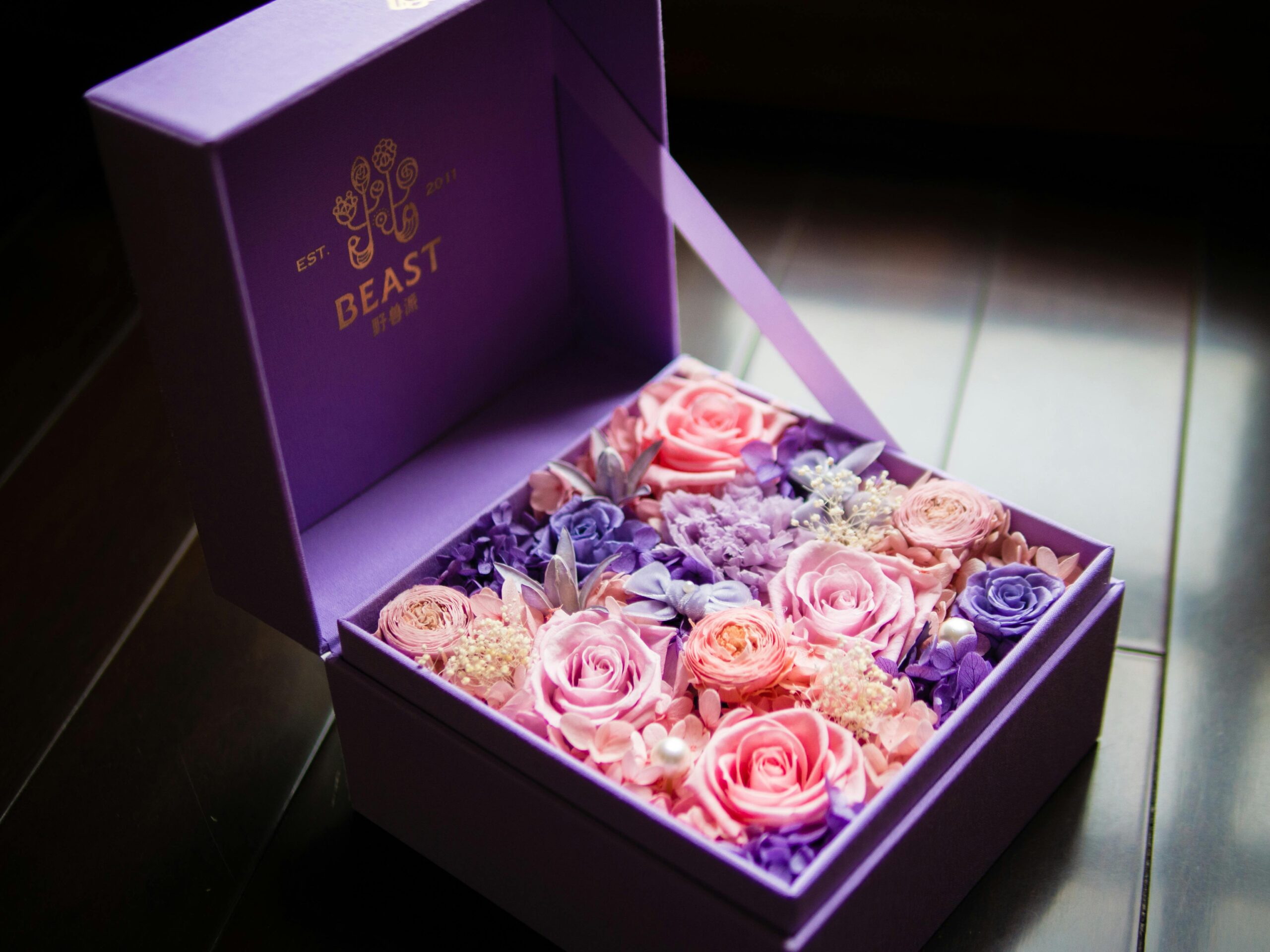 Purple gift box with vibrant pink and purple flowers, perfect for special occasions.
