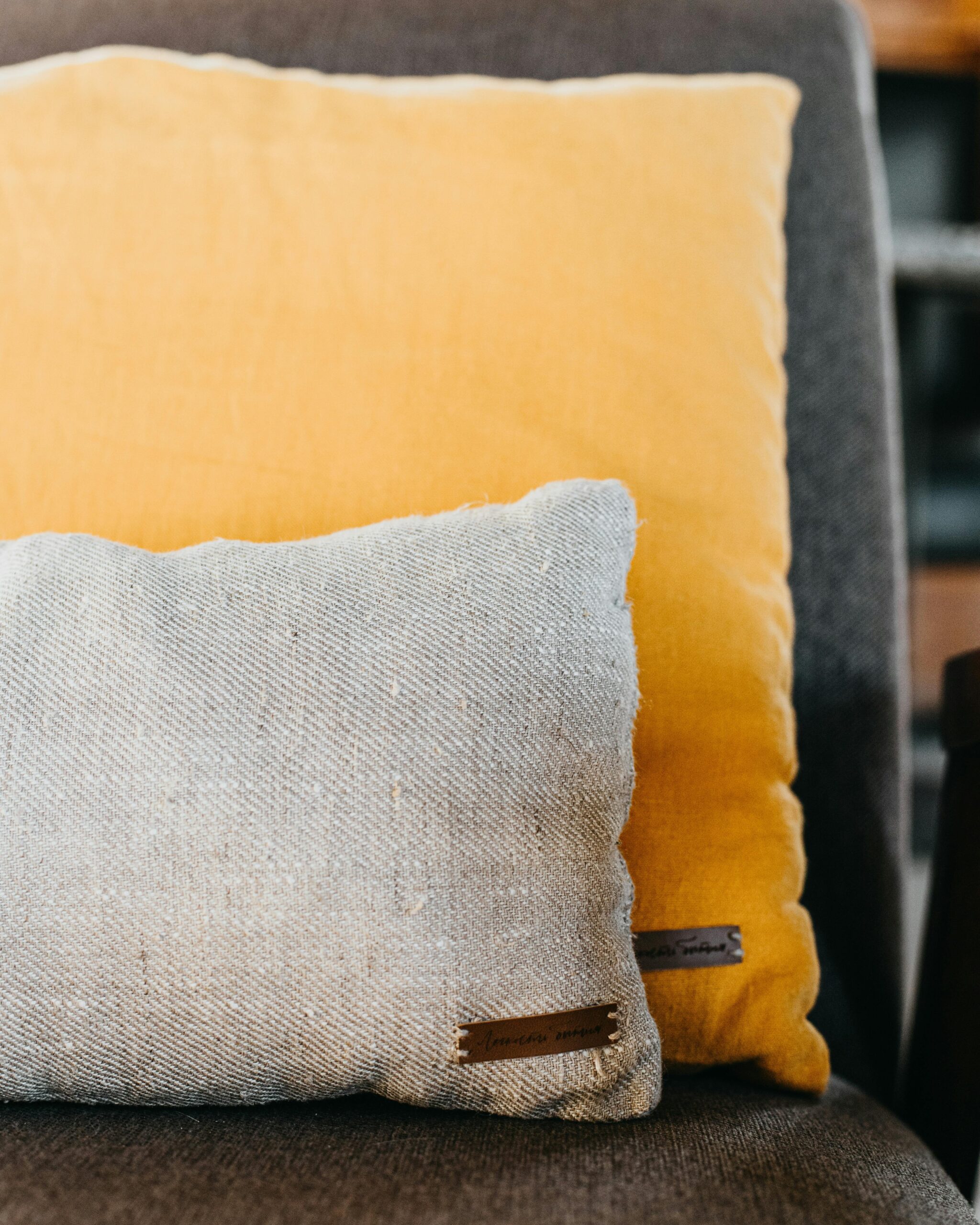 A close-up view of two textured pillows on a gray couch, showcasing modern home decor.